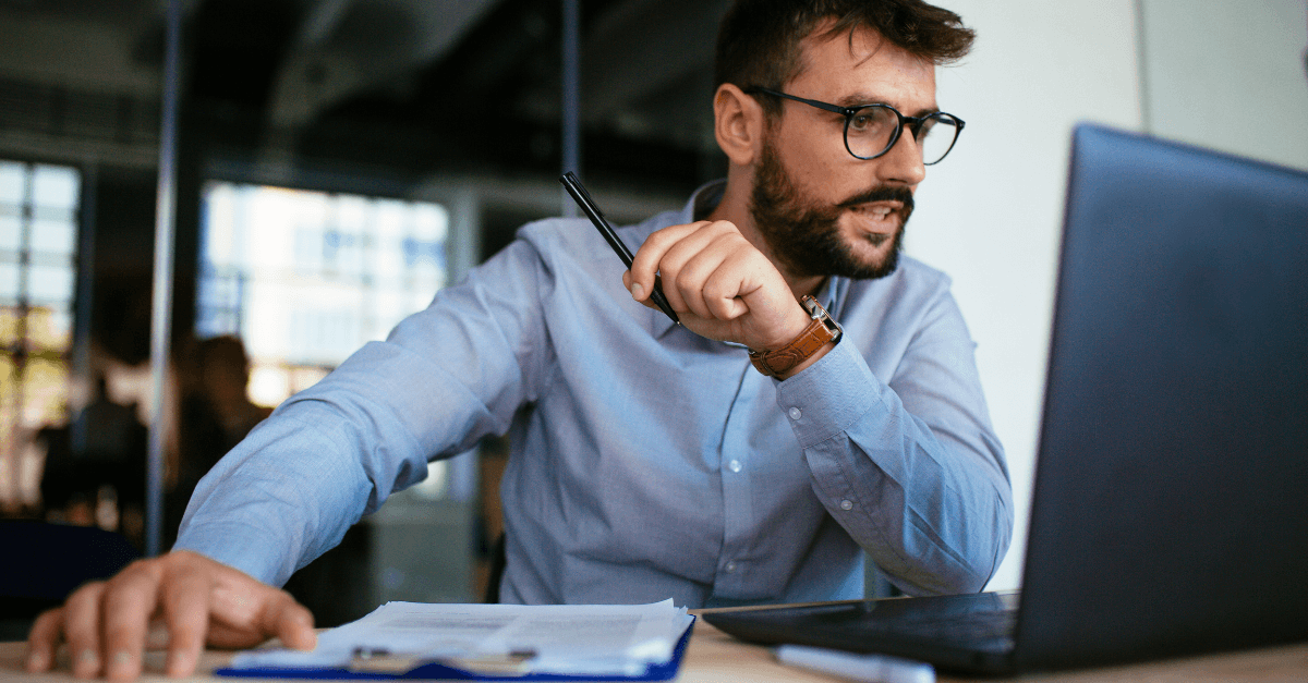 Man in blue shirt looking at laptop